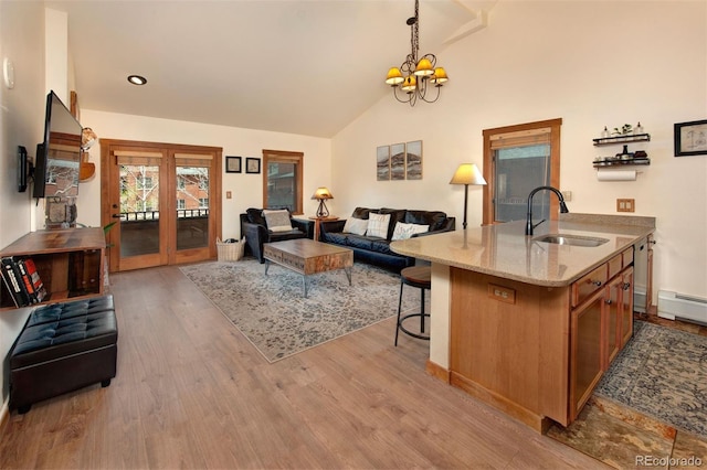 91 River Run Rd Unit 8140, Keystone, CO 80435 - living room with wood finished floors, french doors, a chandelier, high vaulted ceiling, and baseboard heating