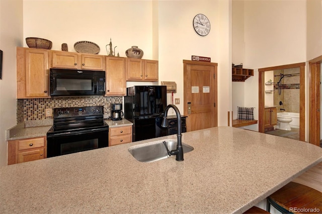 91 River Run Rd Unit 8140, Keystone, CO 80435 - kitchen with black appliances, a sink, a towering ceiling, light countertops, and decorative backsplash