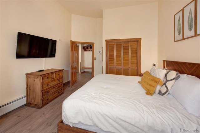 91 River Run Rd Unit 8140, Keystone, CO 80435 - bedroom with a baseboard heating unit, a closet, wood finished floors, and a towering ceiling