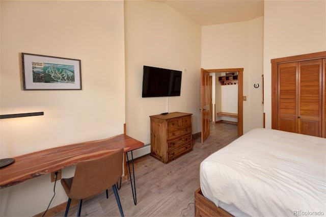 91 River Run Rd Unit 8140, Keystone, CO 80435 - bedroom with light wood-type flooring, a baseboard heating unit, a closet, and high vaulted ceiling