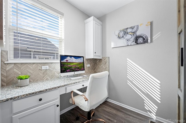 office with built in desk and dark hardwood / wood-style floors