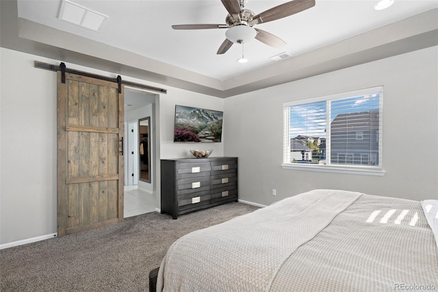 bedroom with light carpet, a barn door, and ceiling fan