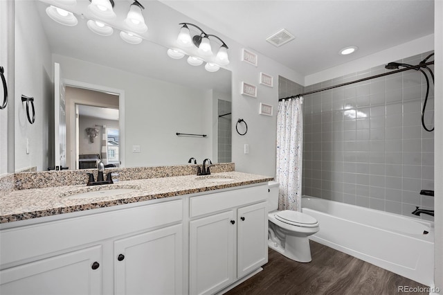 full bathroom featuring hardwood / wood-style flooring, vanity, toilet, and shower / bath combo