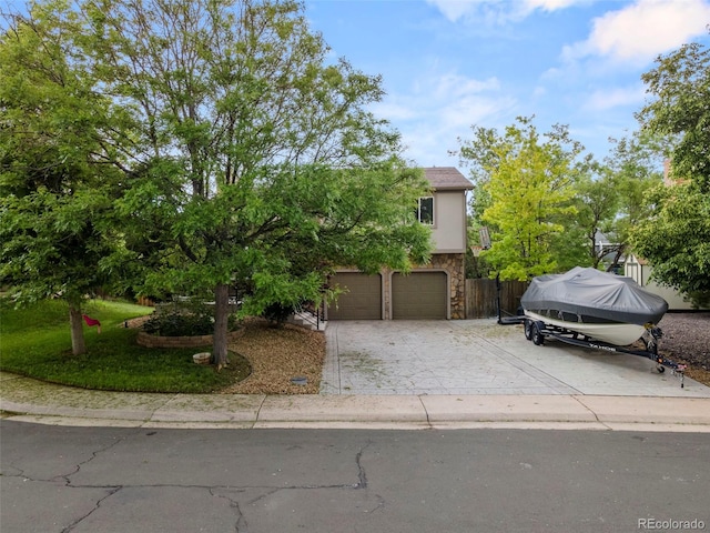 view of front of home featuring stone siding, concrete driveway, and stucco siding