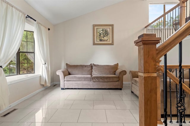 living area featuring lofted ceiling, stairs, baseboards, and a wealth of natural light