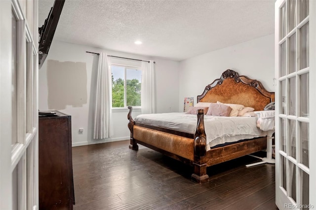 bedroom with baseboards, dark wood finished floors, a textured ceiling, and french doors