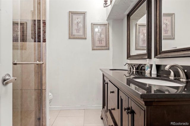 bathroom with tile patterned flooring, a sink, toilet, and baseboards