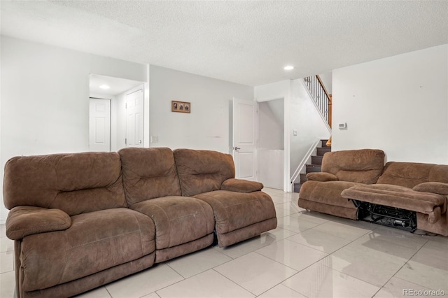 living area with recessed lighting, stairway, and a textured ceiling