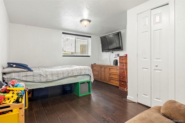 bedroom with dark wood-style flooring and a closet