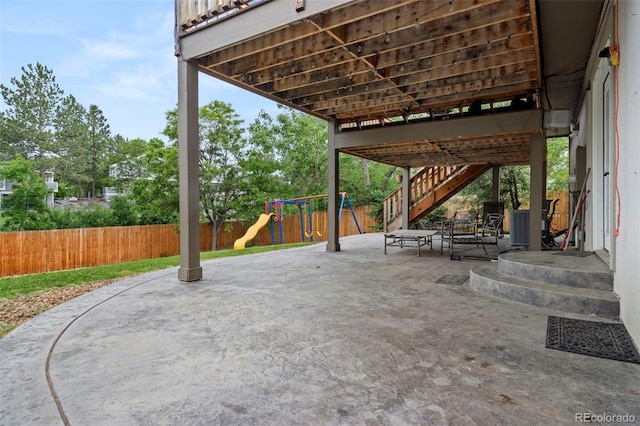 view of patio / terrace featuring a fenced backyard, stairway, and a playground