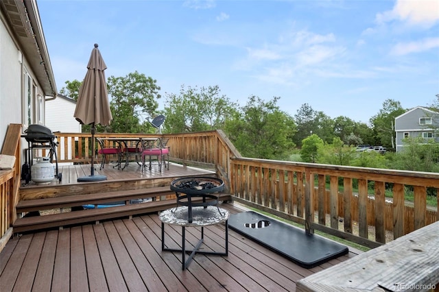 wooden deck with outdoor dining space and area for grilling