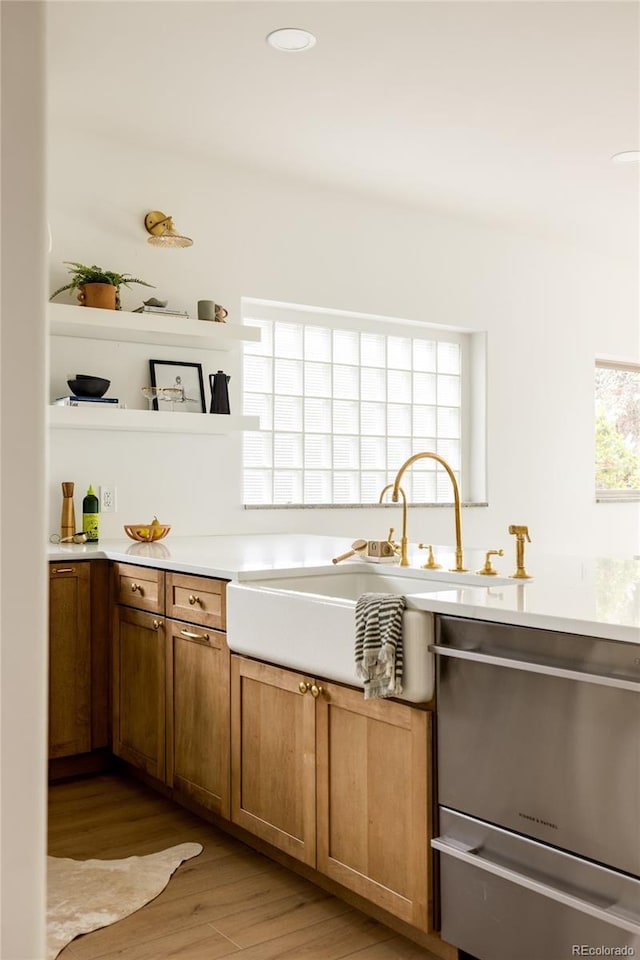 3445 S Clermont St, Denver, CO 80222 - kitchen with stainless steel dishwasher, open shelves, light wood-style flooring, light countertops, and brown cabinets