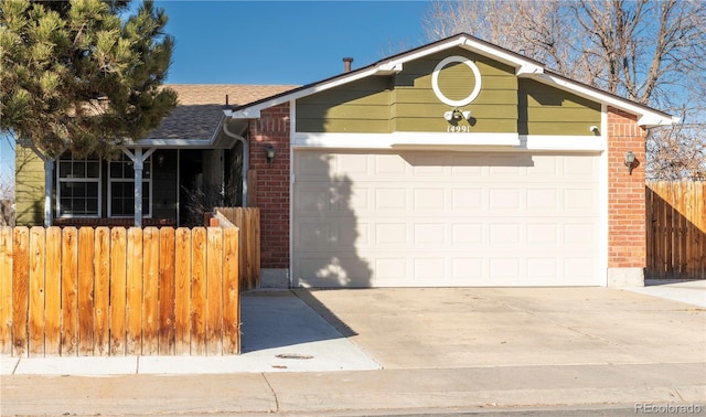 ranch-style home with fence, concrete driveway, an attached garage, a shingled roof, and brick siding