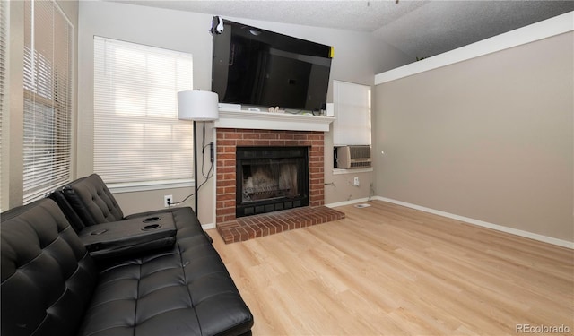 living area featuring baseboards, a brick fireplace, wood finished floors, and vaulted ceiling