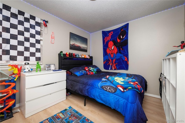 bedroom with light wood-style flooring and a textured ceiling