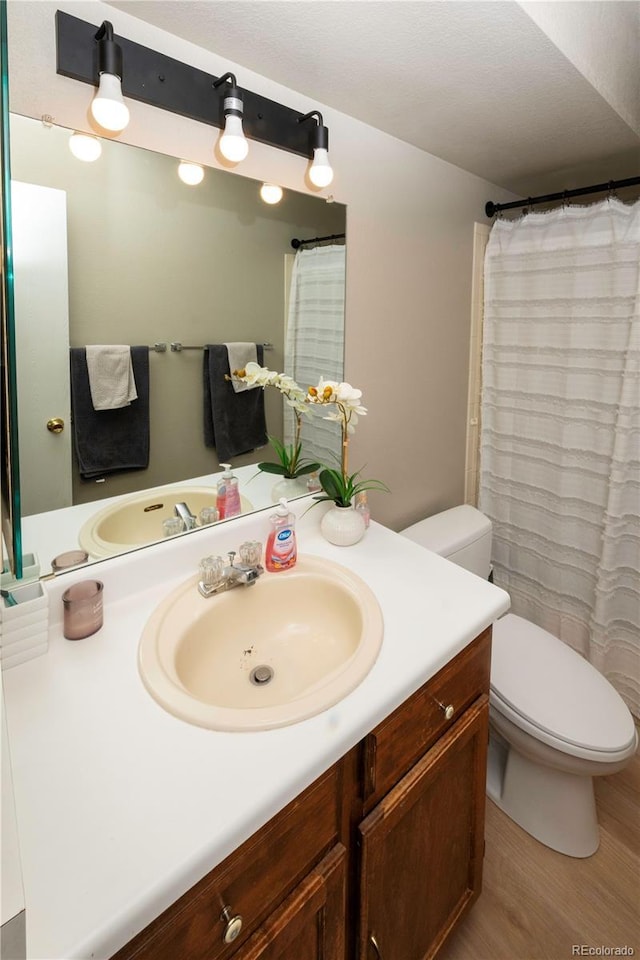 full bath with vanity, toilet, and wood finished floors