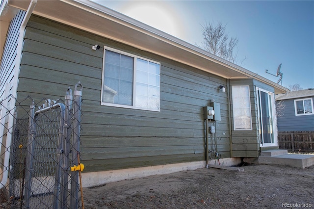 view of side of home featuring fence and entry steps