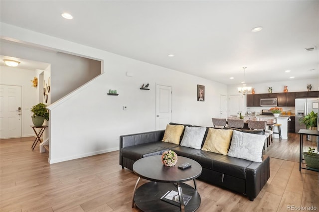 living room featuring light hardwood / wood-style floors and a notable chandelier