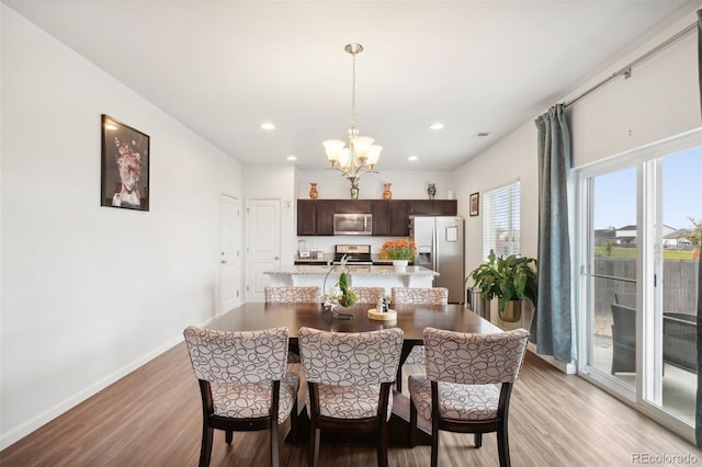 dining space featuring light hardwood / wood-style flooring and a chandelier