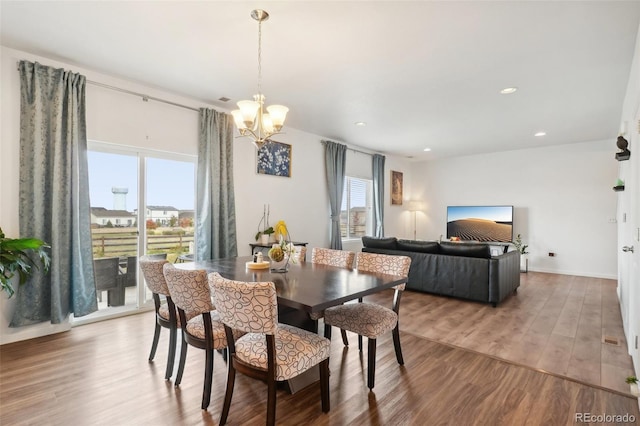 dining space featuring hardwood / wood-style flooring and a chandelier