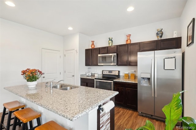 kitchen featuring appliances with stainless steel finishes, sink, a kitchen breakfast bar, beverage cooler, and dark wood-type flooring