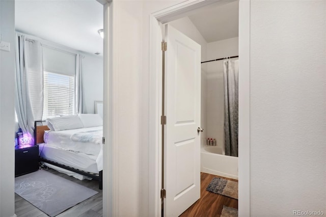 bathroom featuring hardwood / wood-style flooring and shower / bathtub combination with curtain