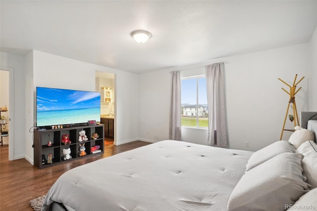 bedroom with dark hardwood / wood-style floors and ensuite bath