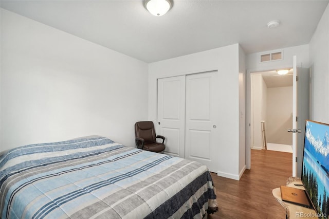 bedroom featuring dark wood-type flooring and a closet