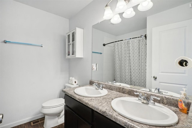 bathroom with vanity, toilet, walk in shower, and hardwood / wood-style floors