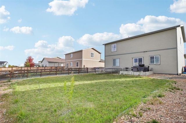 back of house featuring a patio and a lawn