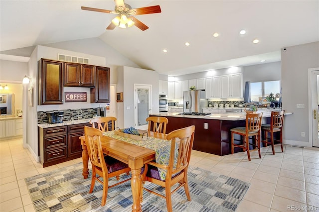 tiled dining area featuring lofted ceiling and ceiling fan