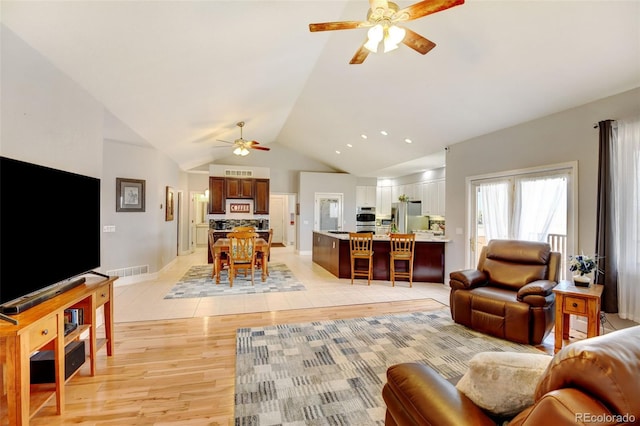 living room with light wood-type flooring, lofted ceiling, and ceiling fan