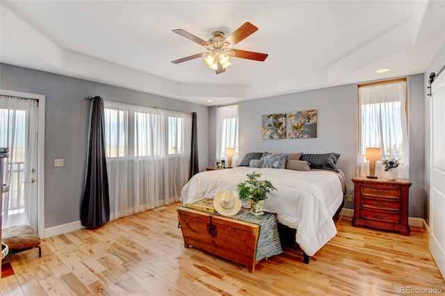 bedroom with ceiling fan, multiple windows, access to exterior, and light wood-type flooring