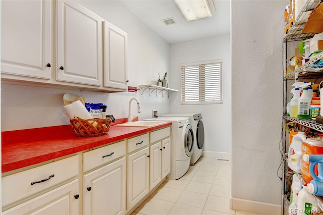 washroom with cabinets, sink, independent washer and dryer, and light tile patterned floors