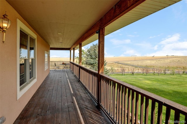 wooden deck featuring a yard and a rural view