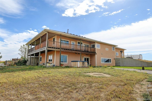 rear view of property with a balcony and a yard