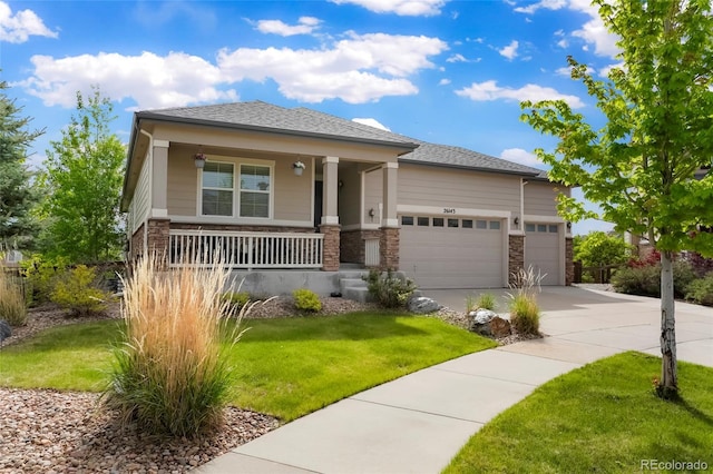 26143 E Fremont Pl, Aurora, CO 80016 - prairie-style home featuring a porch, an attached garage, concrete driveway, and a front lawn