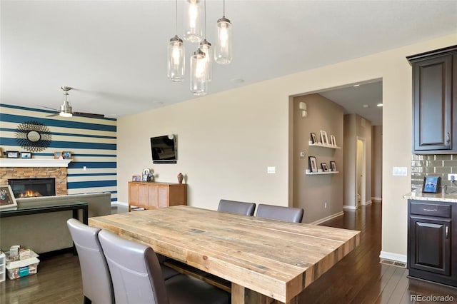26143 E Fremont Pl, Aurora, CO 80016 - dining area featuring dark wood finished floors, a ceiling fan, baseboards, an accent wall, and wallpapered walls