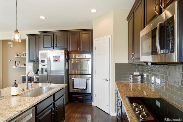 26143 E Fremont Pl, Aurora, CO 80016 - kitchen featuring stainless steel appliances, a sink, dark wood-type flooring, dark brown cabinetry, and light stone counters