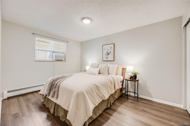 1349 Race St Unit 5, Denver, CO 80206 - bedroom featuring a baseboard radiator, wood finished floors, a textured ceiling, baseboards, and cooling unit