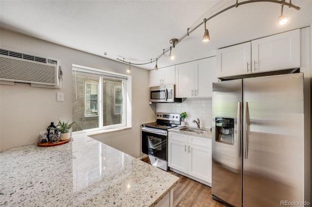 1349 Race St Unit 5, Denver, CO 80206 - kitchen featuring stainless steel appliances, a sink, white cabinets, tasteful backsplash, and light wood finished floors