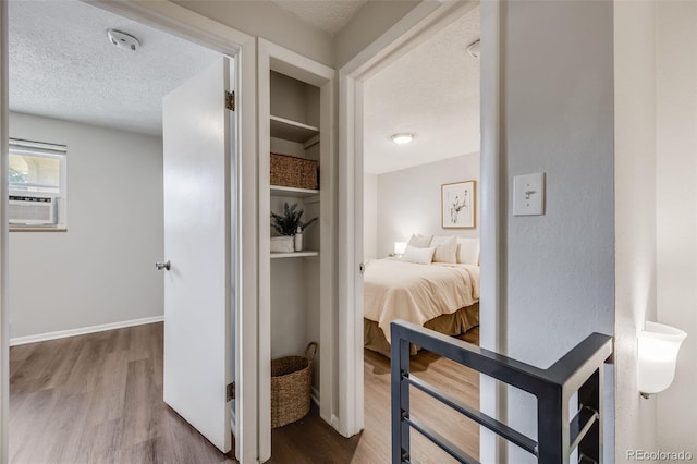 1349 Race St Unit 5, Denver, CO 80206 - hallway featuring wood finished floors, a textured ceiling, cooling unit, built in shelves, and baseboards