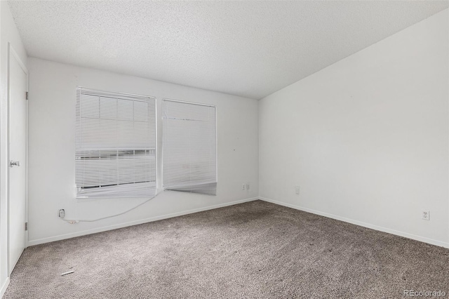 carpeted spare room with baseboards and a textured ceiling