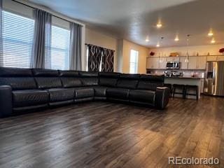 living area with dark wood-type flooring and recessed lighting