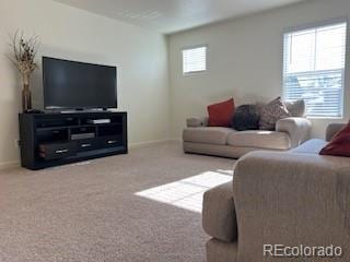 living area featuring carpet flooring and baseboards