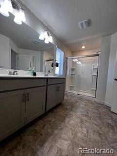 full bath with a stall shower, a sink, and double vanity