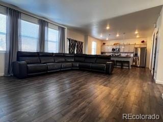 living room with baseboards and dark wood-type flooring