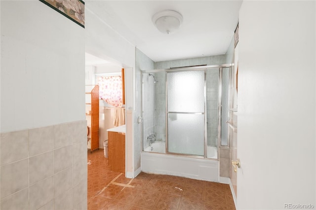 full bathroom with bath / shower combo with glass door and tile walls