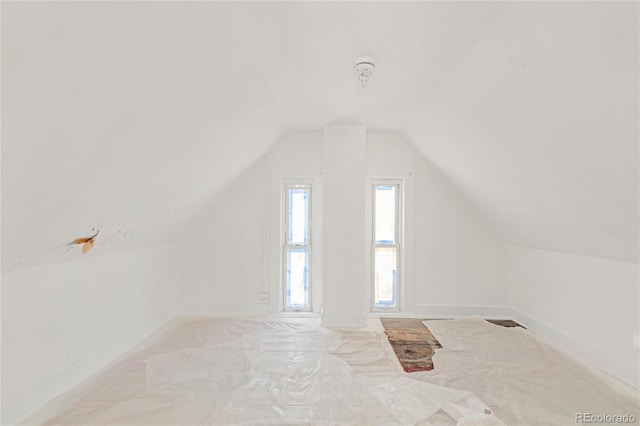 additional living space featuring lofted ceiling and baseboards