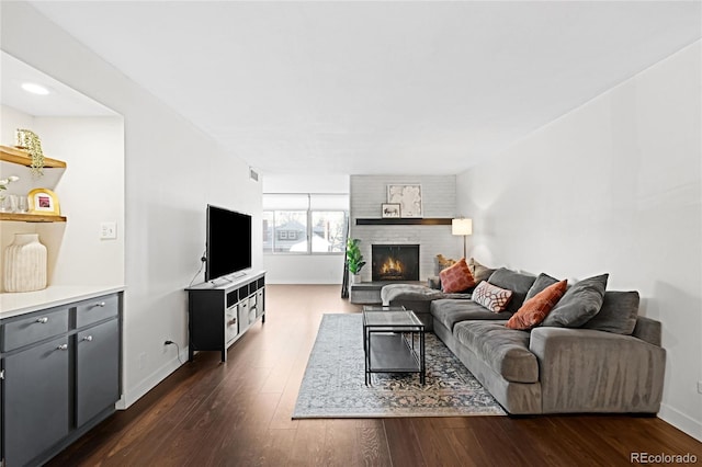 living room featuring a fireplace, dark wood finished floors, and baseboards